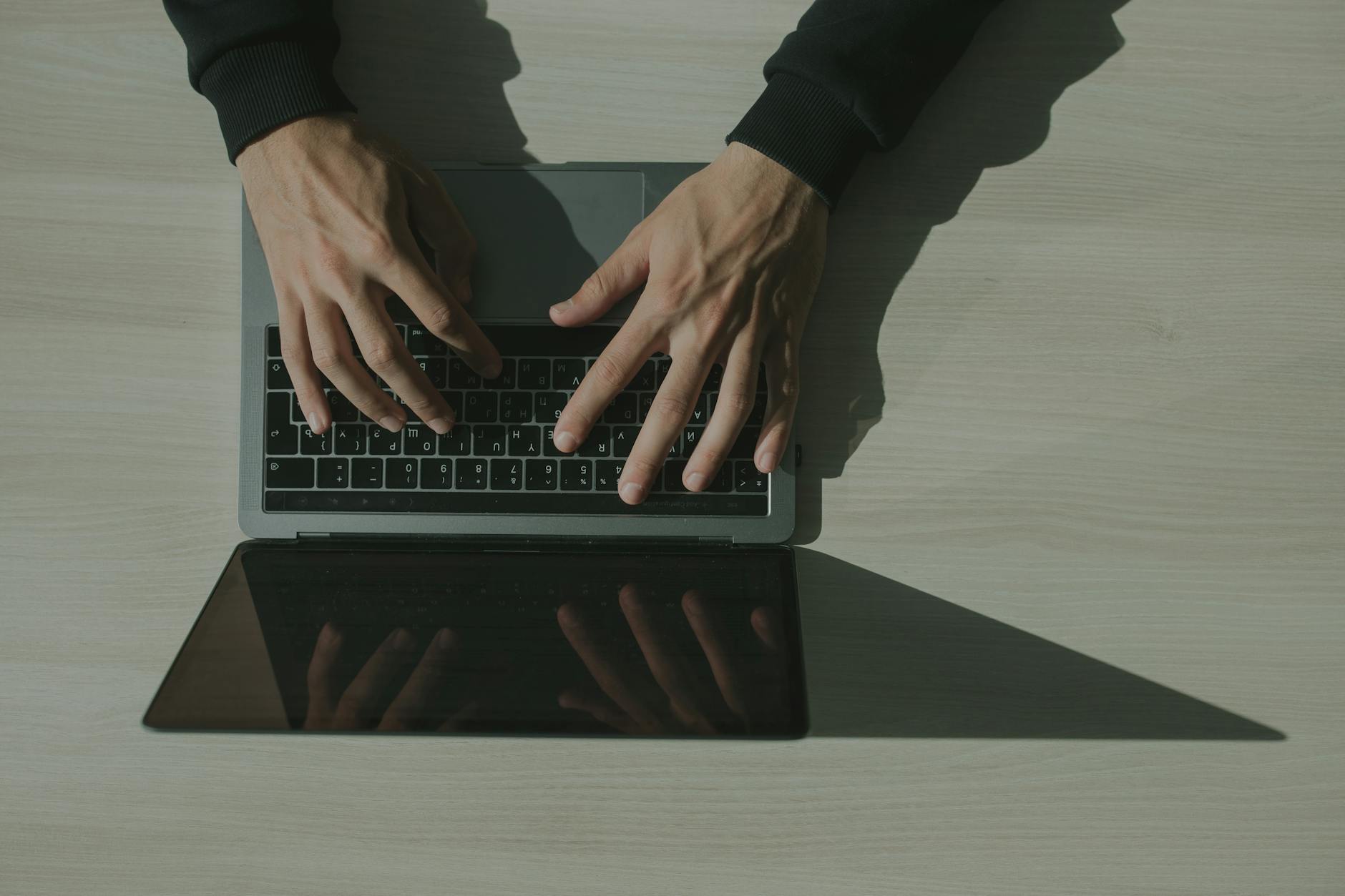 hands typing on a laptop keyboard